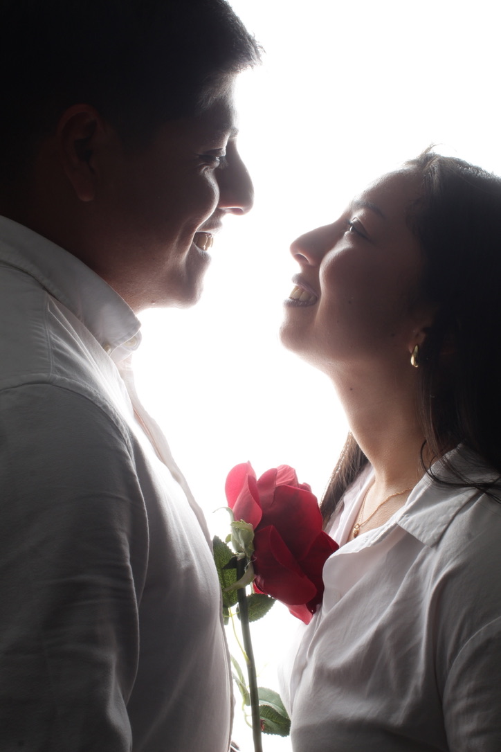 Junior y Diana mirandose, con una rosa entre los dos